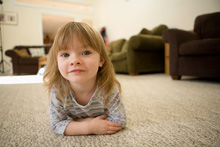 young girl laying on a carpet